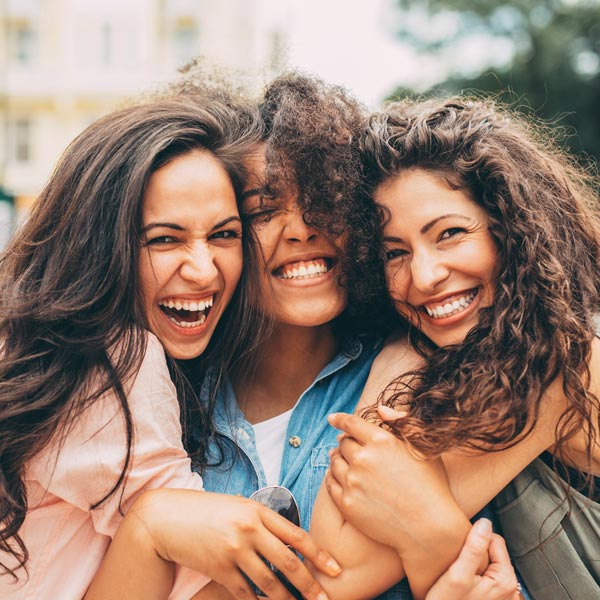 Three best friends hugging each other in the city.